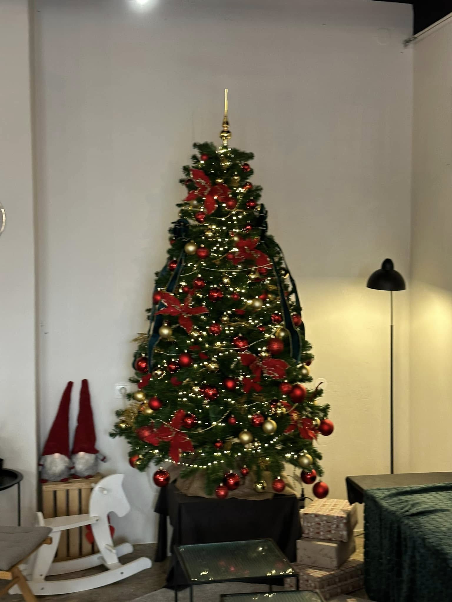 Okrašeno božično drevo. Zlate in rdeče bunkice, pentlje.